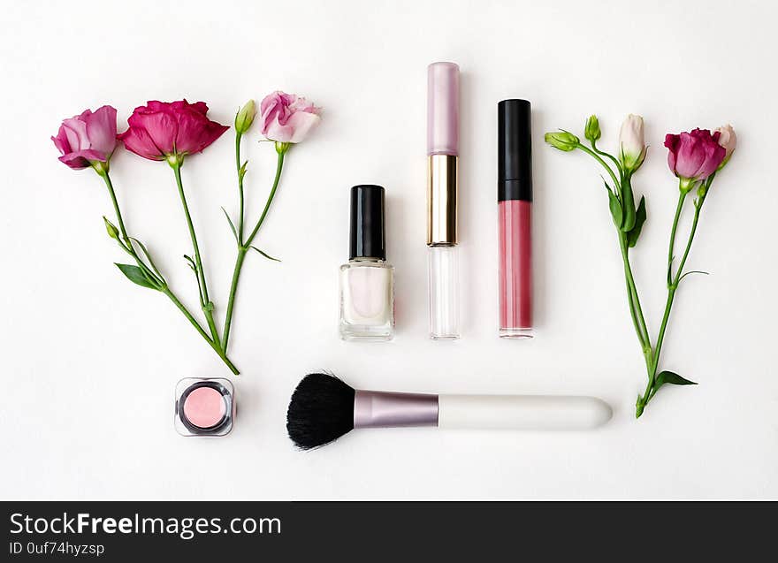 Top view of the working area notebook with pen and decorative cosmetics for makeup, soft brushes and flowers, beautiful background closeup. Top view of the working area notebook with pen and decorative cosmetics for makeup, soft brushes and flowers, beautiful background closeup