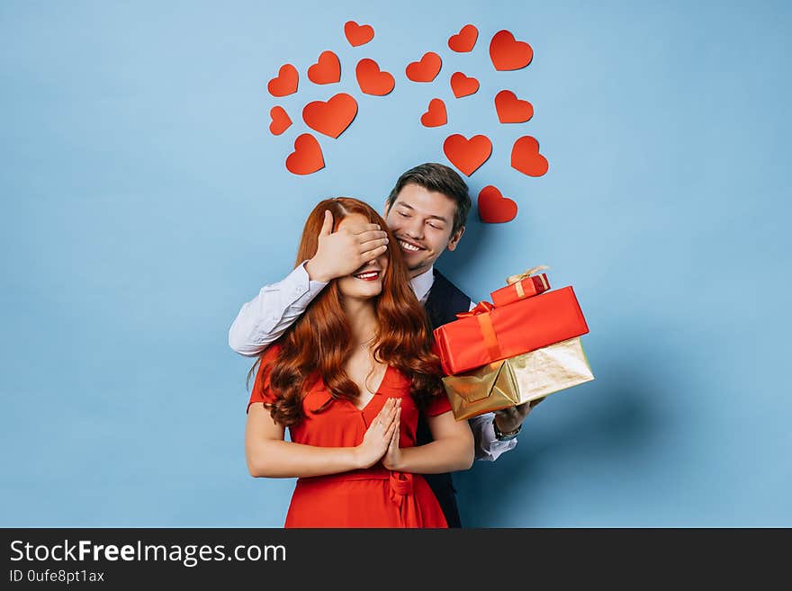 Portrait of young caucasian happy couple on the eve of valentines day, young bearded male gladden his redhaired girlfriend. love concept. Portrait of young caucasian happy couple on the eve of valentines day, young bearded male gladden his redhaired girlfriend. love concept