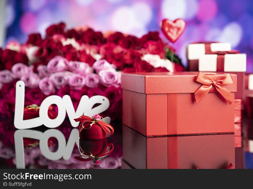 Gifts in boxes, red hearts and big bouquet of natural roses on blue bokeh background. Gifts in boxes, red hearts and big bouquet of natural roses on blue bokeh background.