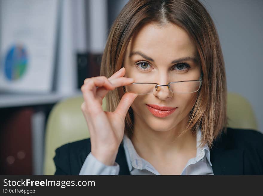 Sexy cute girl holding her glasses and smiling. Beautiful happy businesswoman working at home office