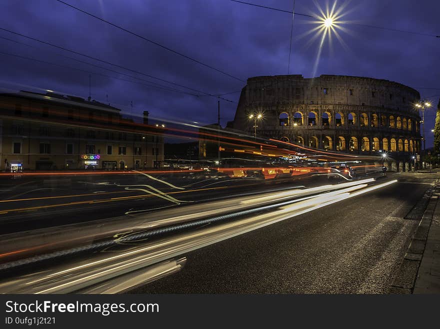 Coliseum at night time with car lights. Shoot taken at dusk. It`s a long exposure to convey more dynamic to the photograph while limiting the amount of people and the many cars that daily populate Rome. Coliseum at night time with car lights. Shoot taken at dusk. It`s a long exposure to convey more dynamic to the photograph while limiting the amount of people and the many cars that daily populate Rome.
