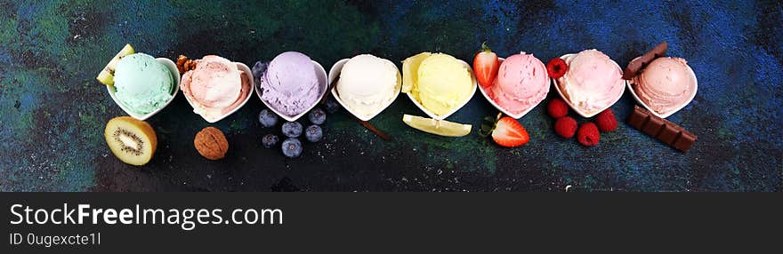 Various of ice cream flavor with fresh blueberry, strawberry, kiwi, lemon, vanilla setup on rustic background . Summer and Sweet ice cream