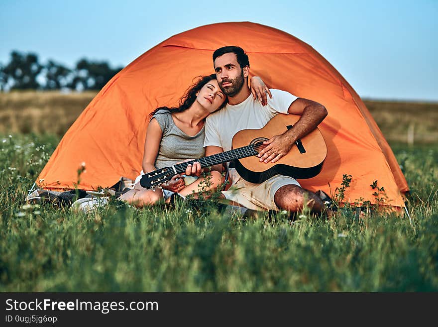 Love concept. Hiking romance. Couple in love happy relaxing nature background. Summer vacation. Boyfriend girlfriend guitar near camping tent. Camping vacation. Camping in mountains. Family travel