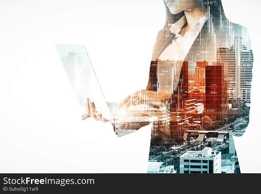 Double exposure of businesswoman silhouette using laptop with stock infograph on city background. Sucess and business concept