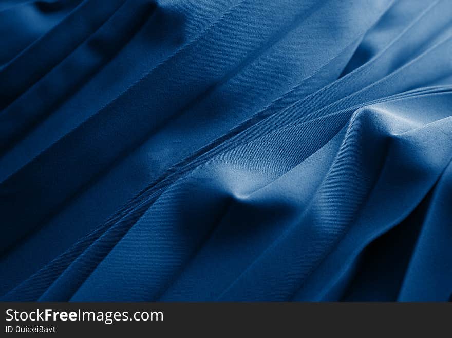 Blue silk or satinfolded fabric. Luxurious fabric cloth gathers glamour background. Dark blue elegant silk background use for