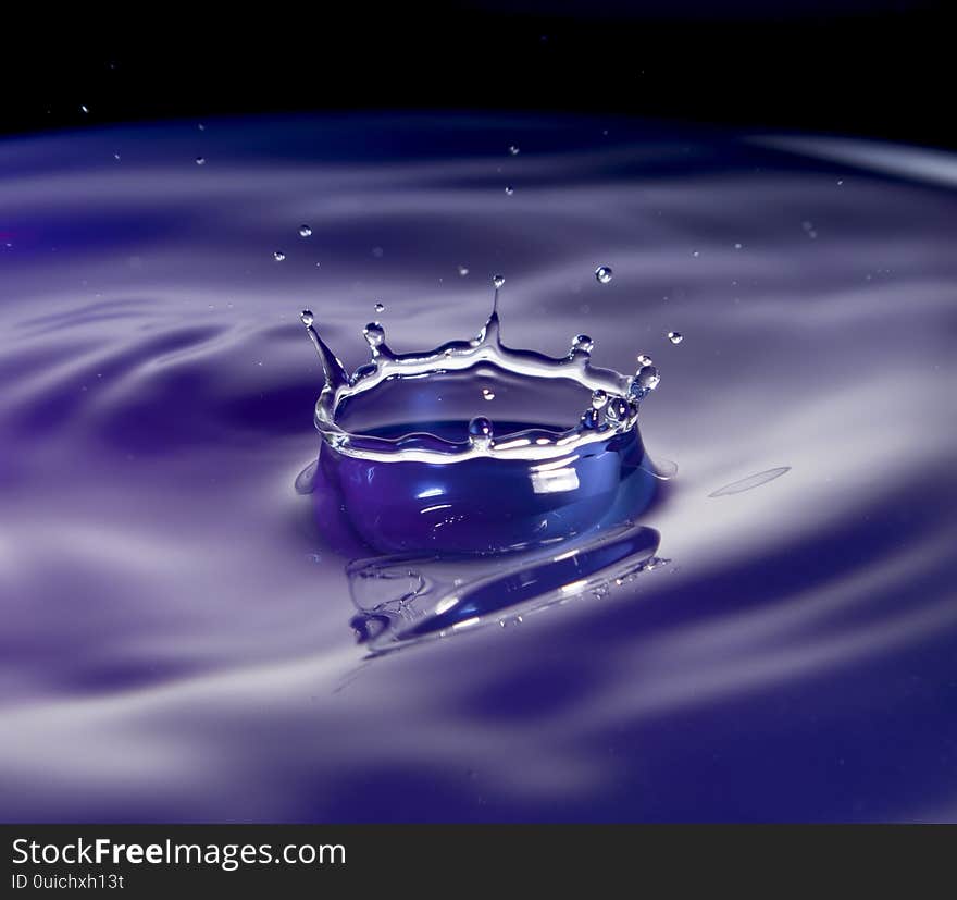 A water splash in purple tone with black background