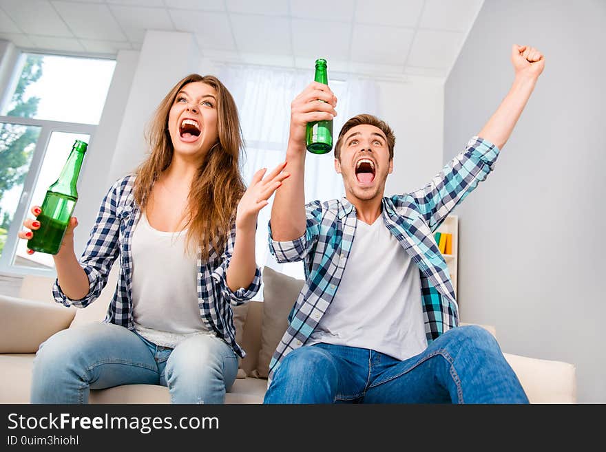 Goal! Happy man and woman with beer triumphing with raised hands