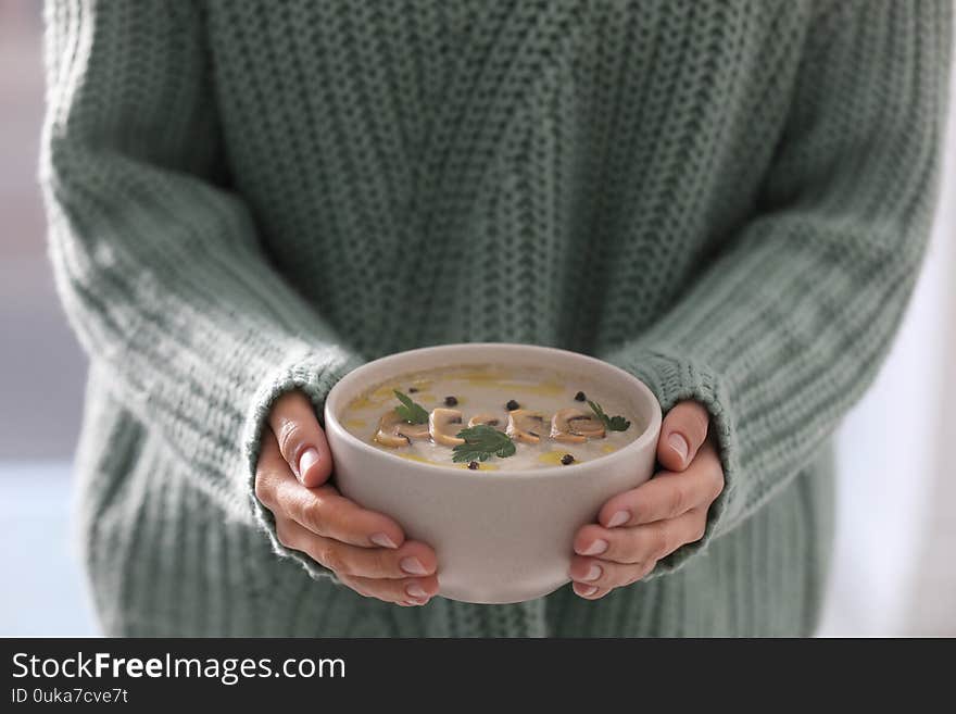 Young woman with bowl of cream soup, closeup