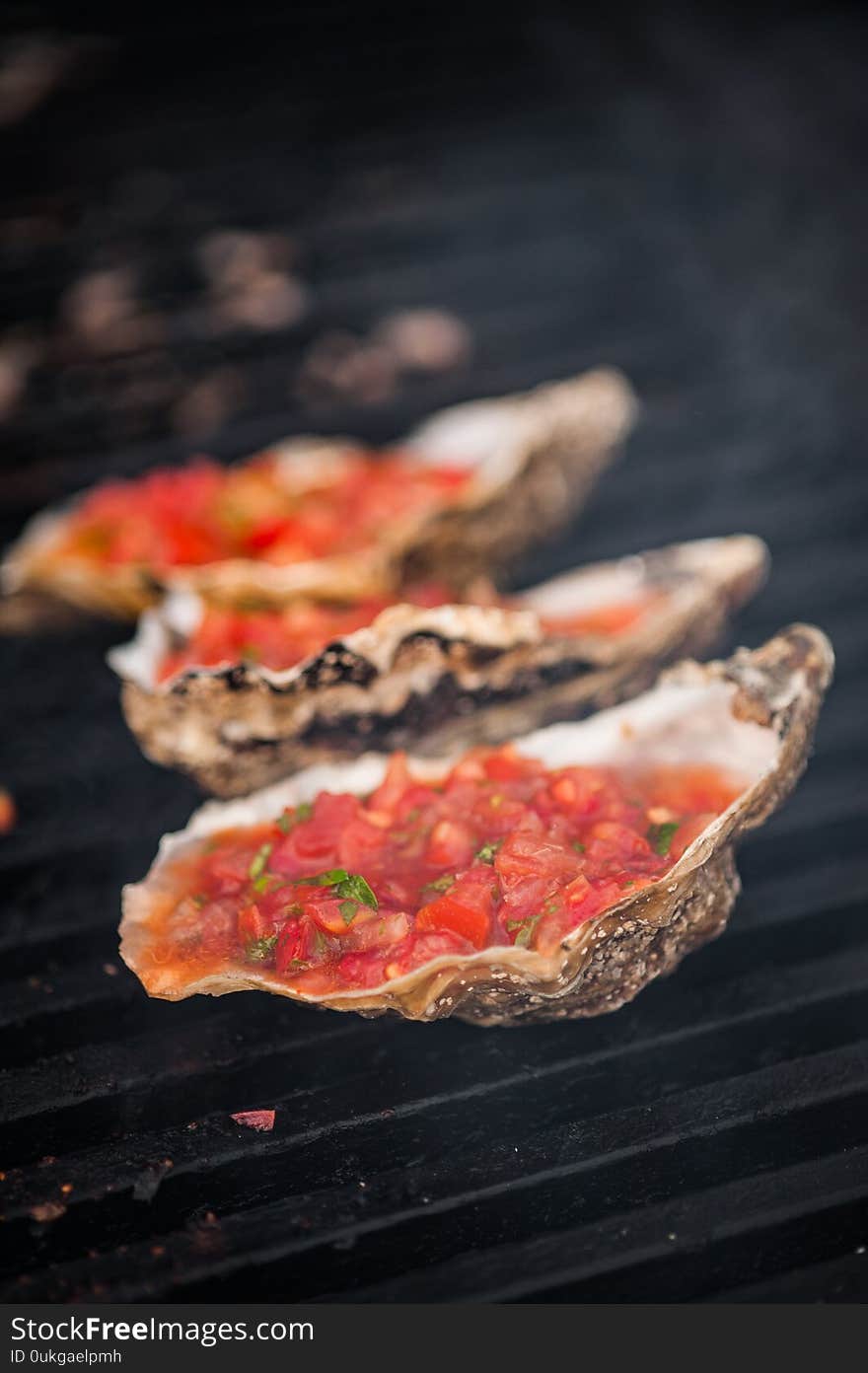 Oysters on the grill. Oysters with tomato sauce. Street food