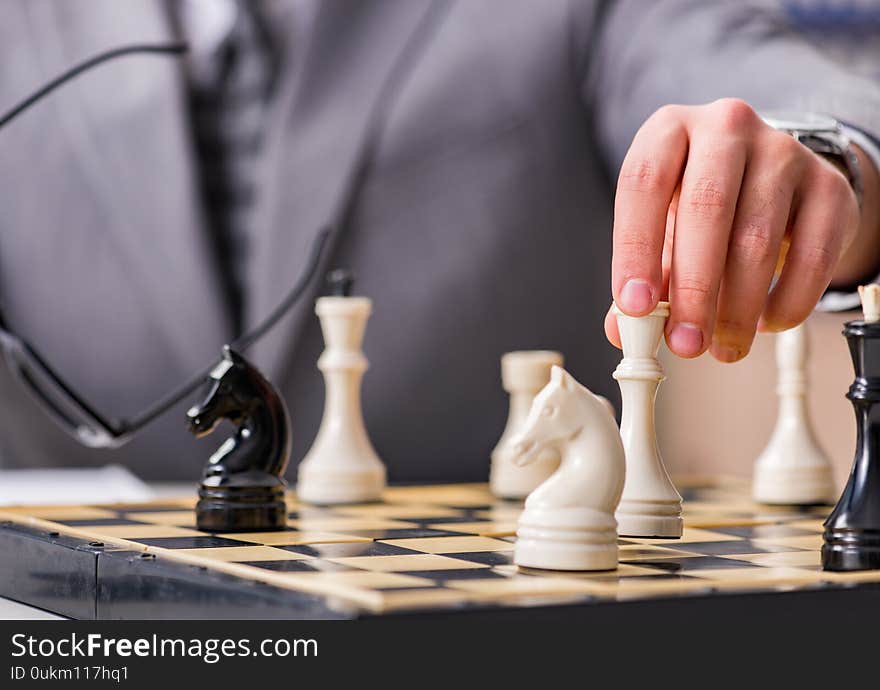 Young businessman playing chess in the office