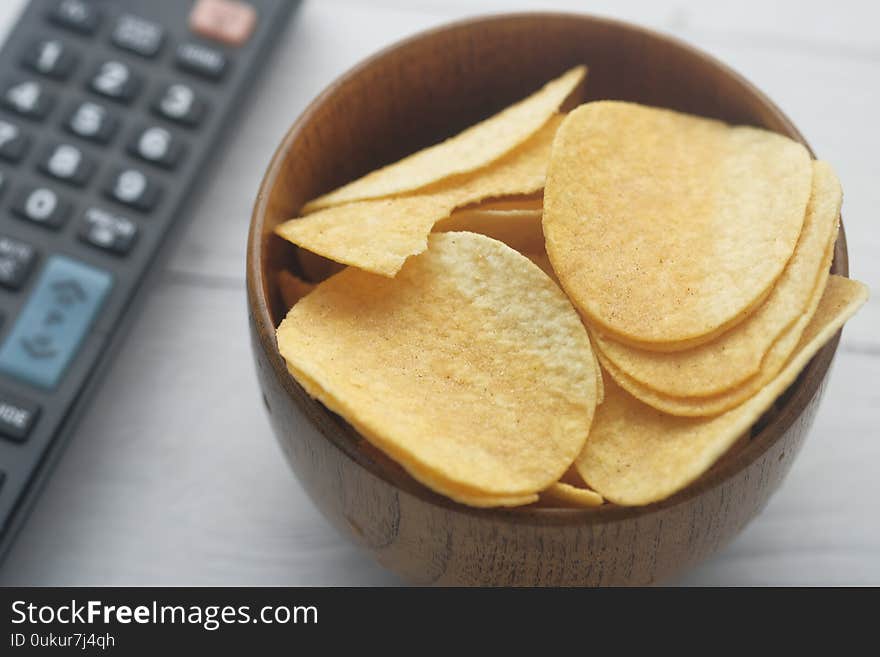 Close up of chips in a bowl with tv remote