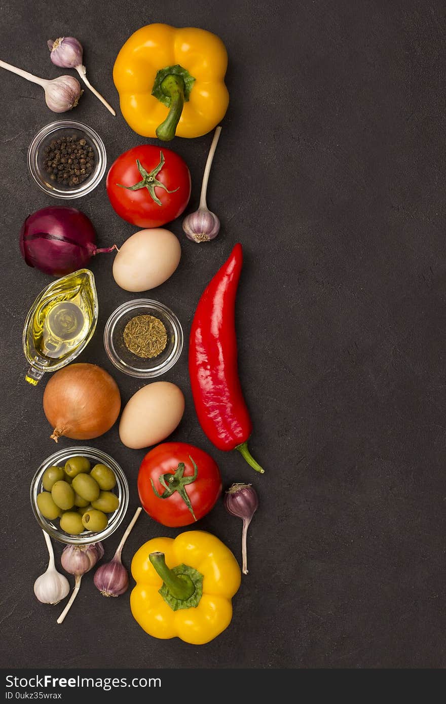 Set of vegetables for a healthy diet, yellow and red peppers, tomatoes onions garlic eggs olives rocket,  spinach.  Healthy food fitness. Flat lay, black background. Copy space