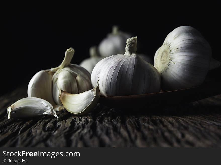 Fresh white garlic on wooden table with black background. Food and healthy concept