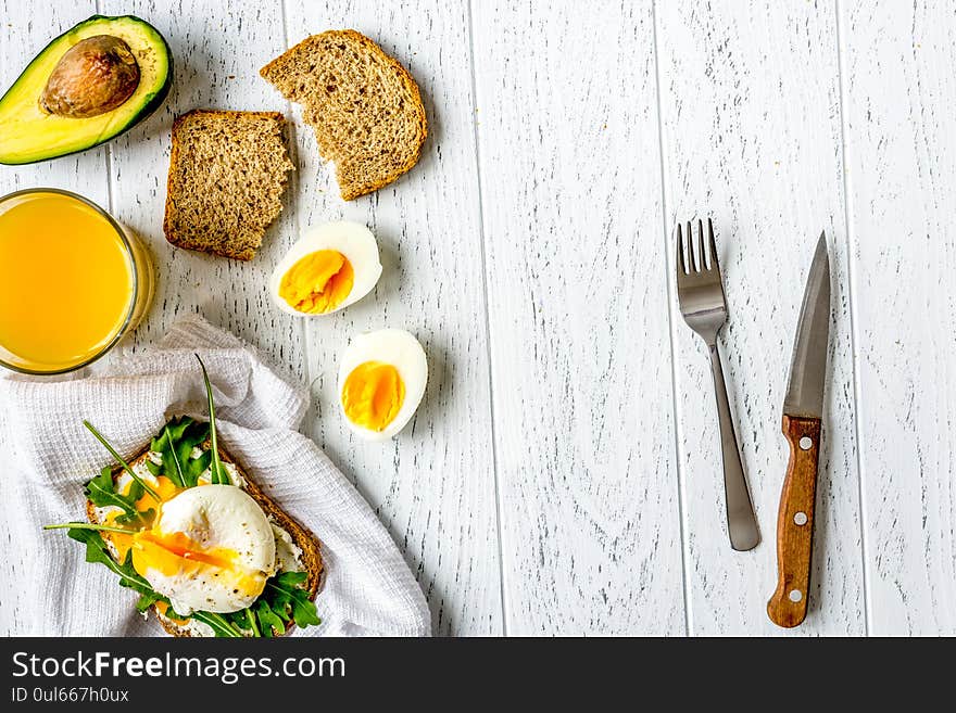 Sandwich with poached eggs on wooden background top view mockup.