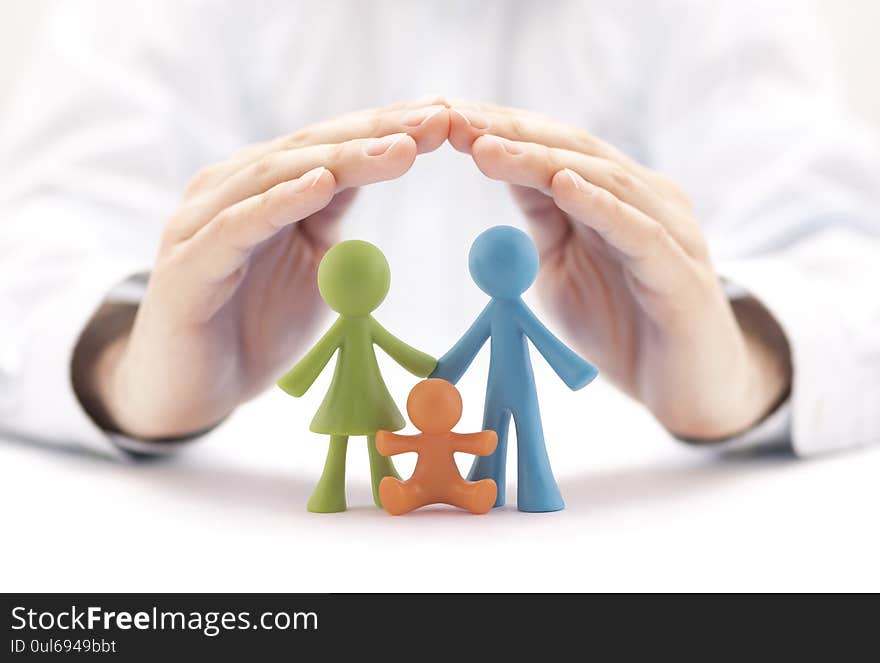 Family insurance concept with colorful family figurines covered by hands