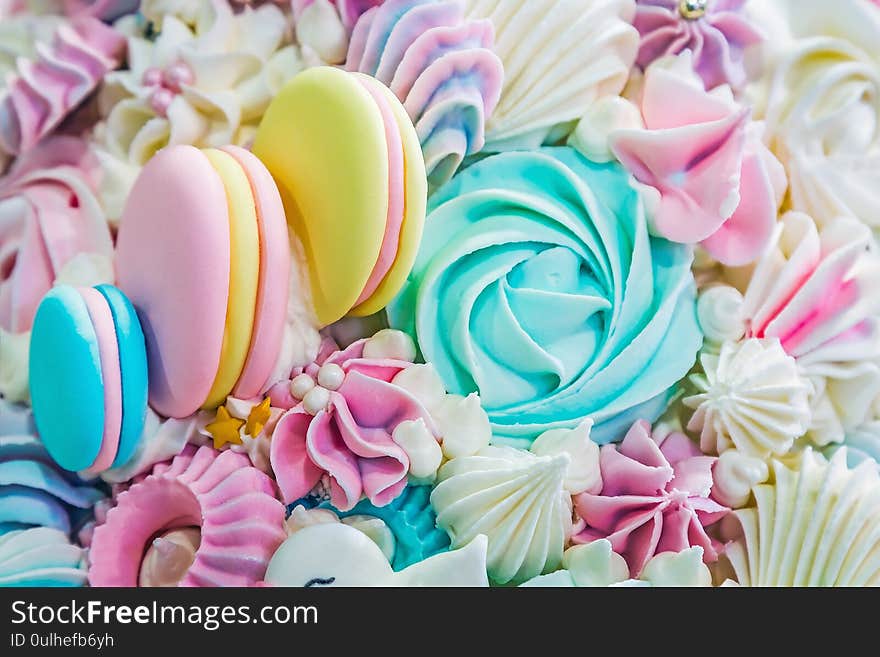 Multicolored background of marshmallow sweets, macaroon cakes and cream. Pastel shades of color