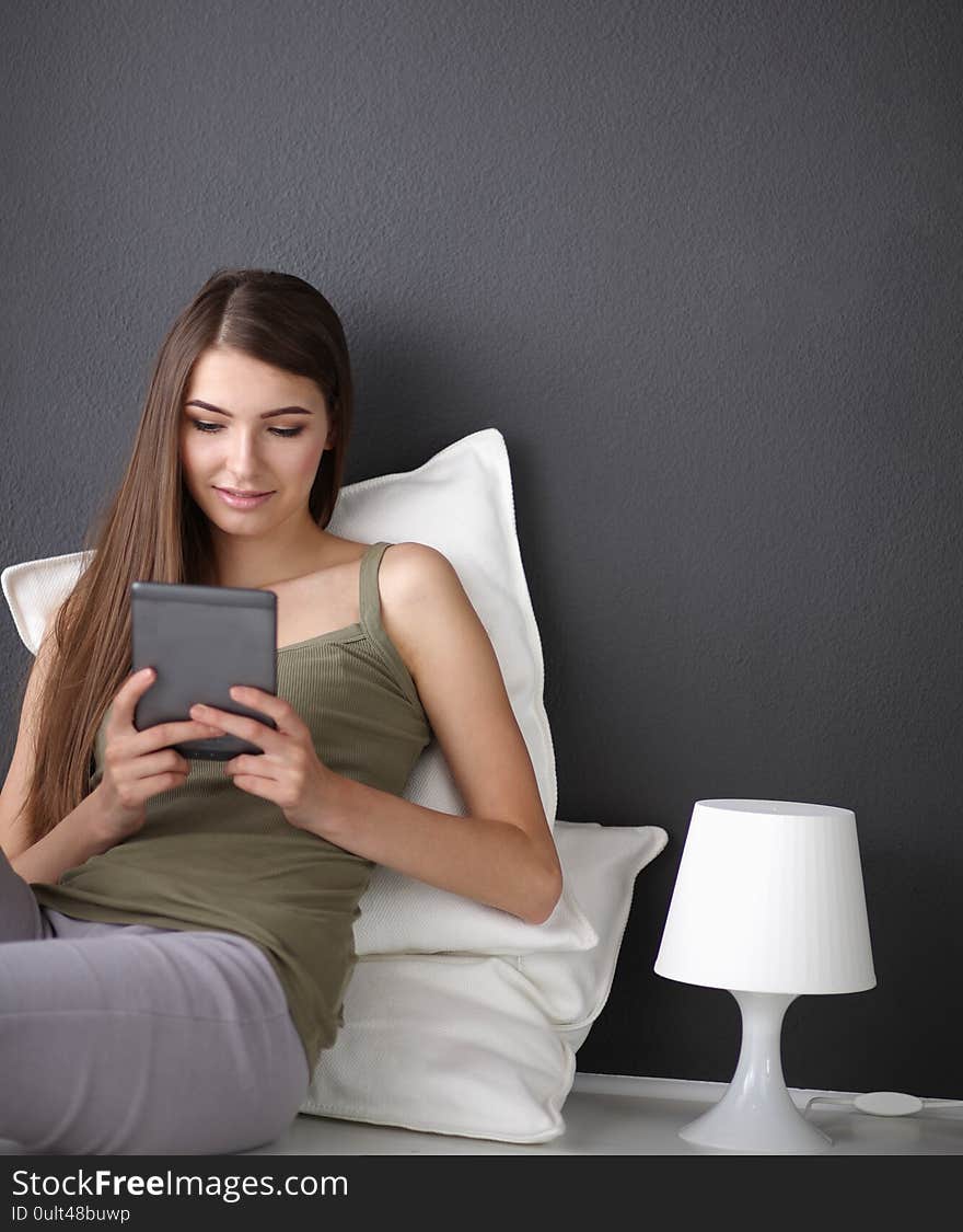 Woman sitting on the floor using a digital tablet.