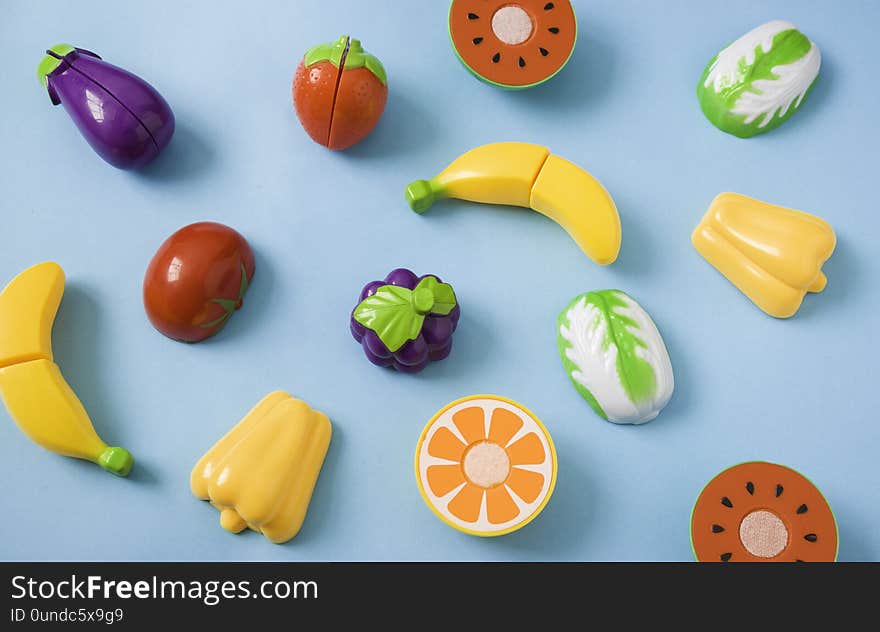 Plastic food children`s toys on a blue background. The concept of healthy eating