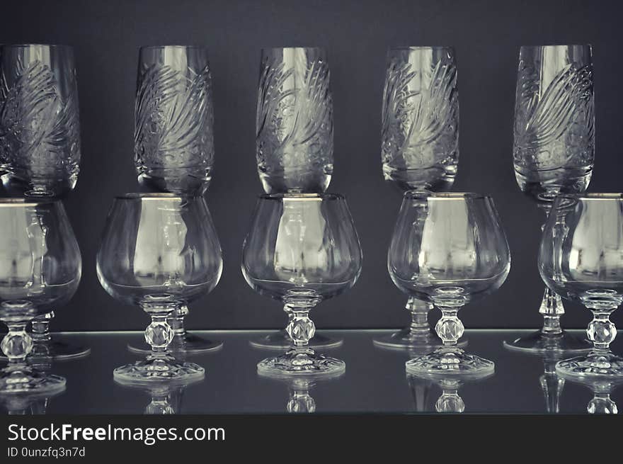 Stylish glasses for alcohol on a dark background. Beautiful crystal tableware. Stylish glasses for alcohol on a dark background. Beautiful crystal tableware.