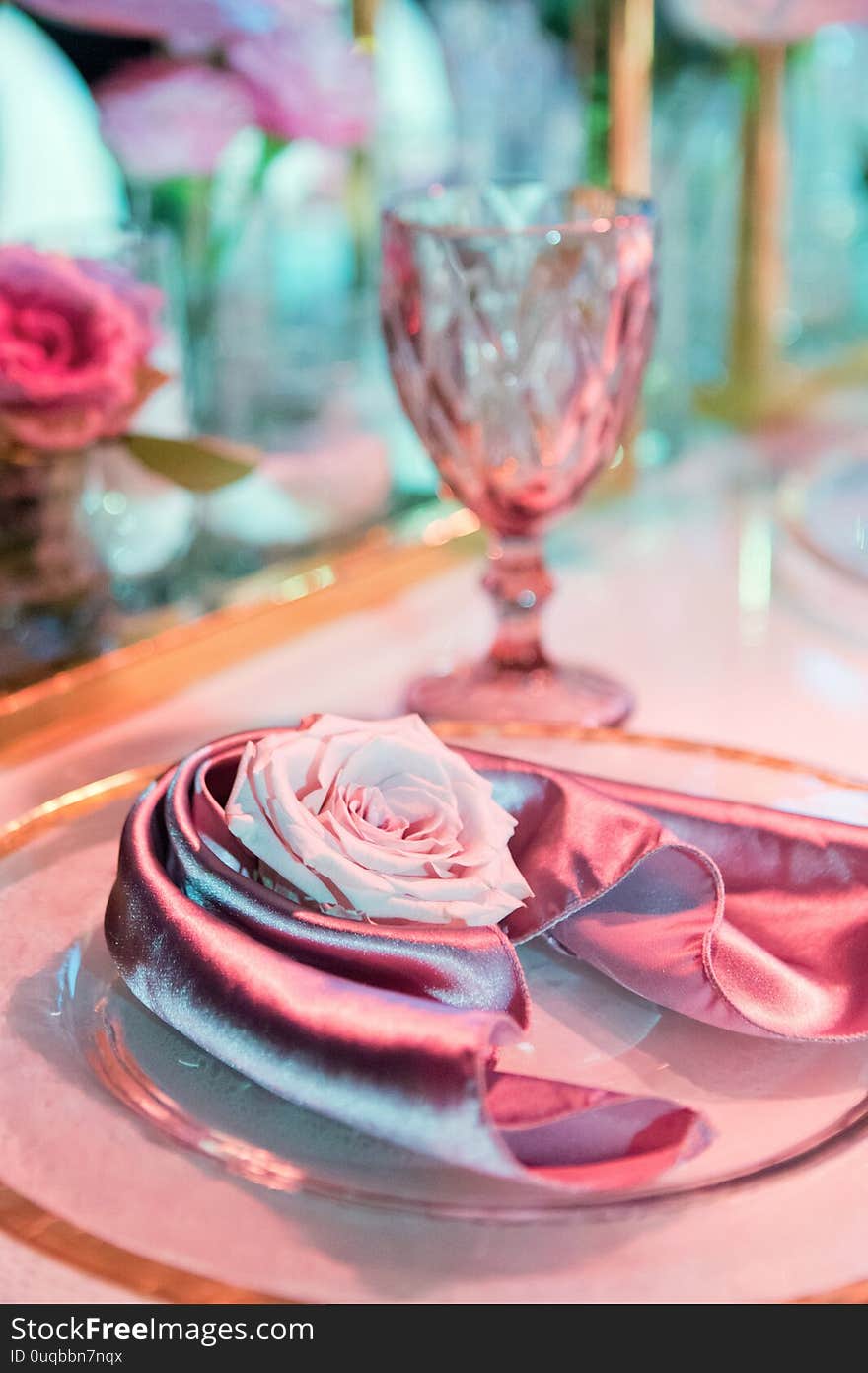 Plate with silk napkin and pink rose. Beautiful table setting with flowers decorations