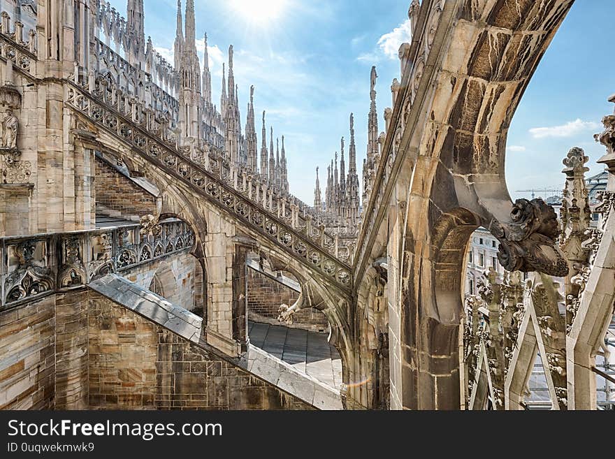 Milan Cathedral roof, Italy, Europe. Milan Cathedral or Duomo di Milano is top landmark of Milan city. Beautiful Gothic architecture of Milan against blue sky. Detail of luxury rooftop decorations