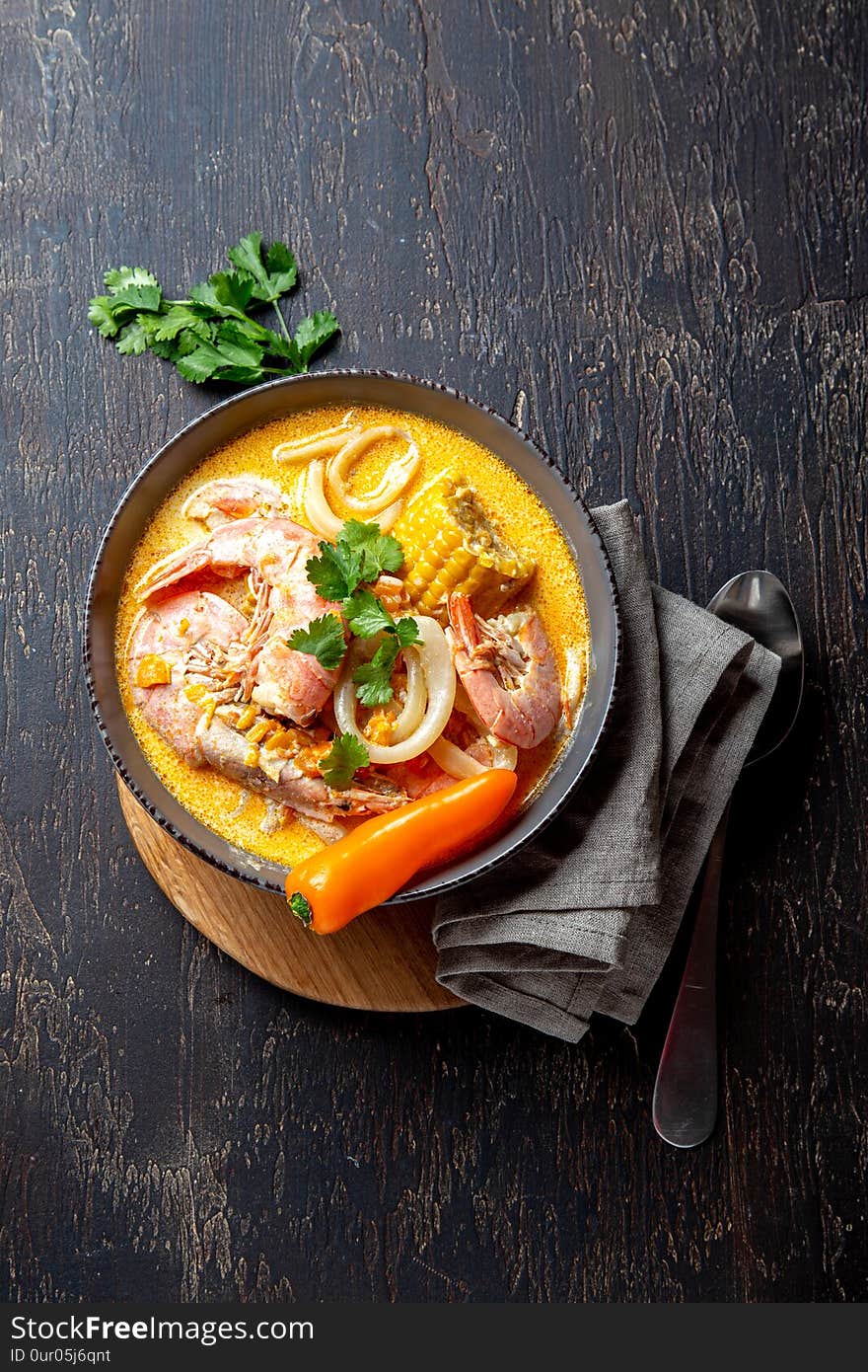 Peruvian seafood soup Chupe de Camarones in gray bowl, top view.