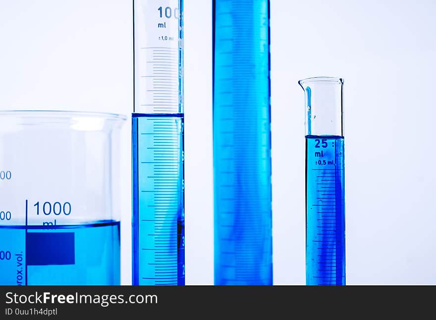 Laboratory equipment with blue liquid inside on white background