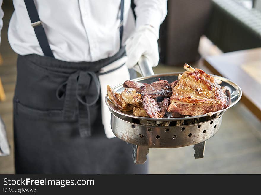 The Waiter Is Holding A Plate Various Grilled Meat Set. Barbecue Restaurant Menu, A Series Of Photos Of Different Meats.