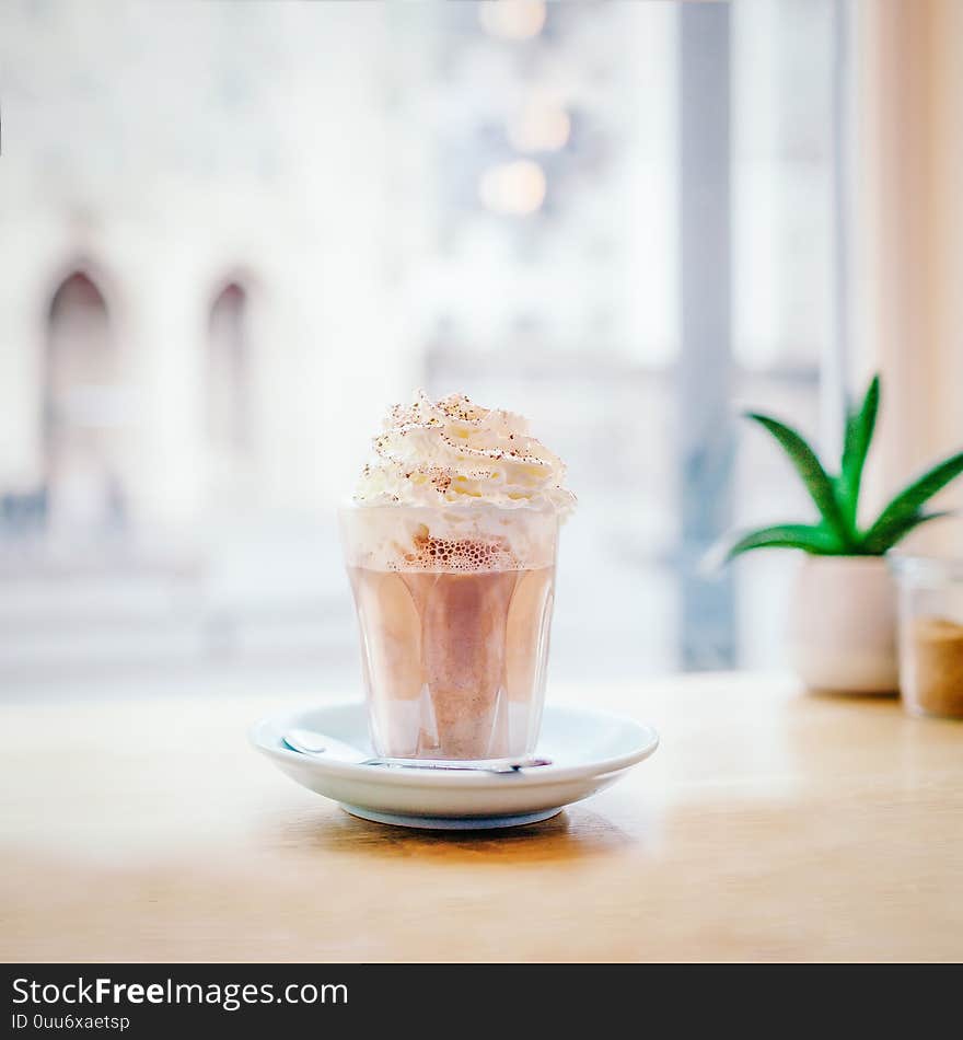 Glass with coffee mocha near the window on the street background