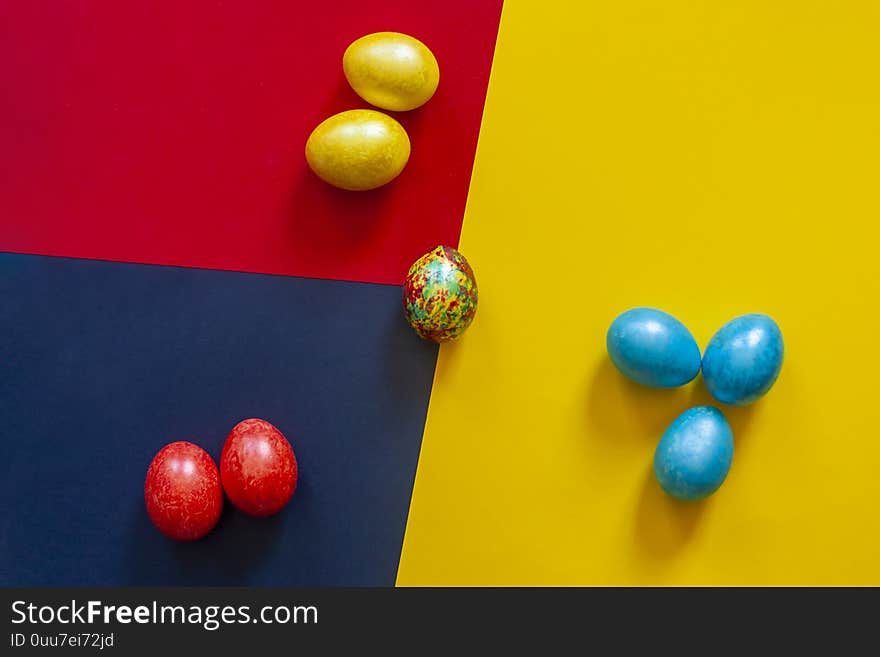 Colorful easter eggs on the bright multicolored background. View from above. Top view. Flat lay image. Colorful easter eggs on the bright multicolored background. View from above. Top view. Flat lay image