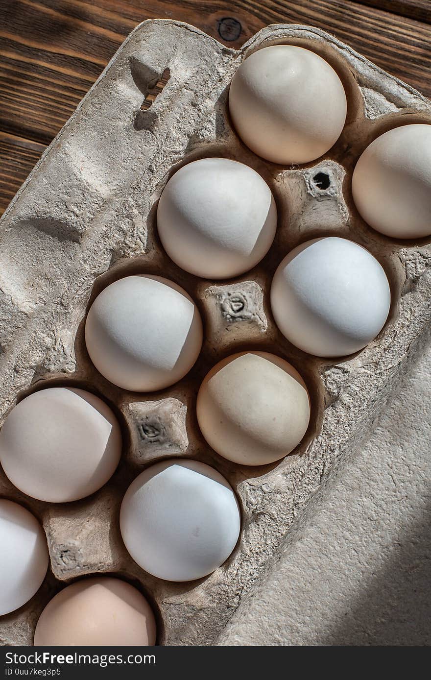 Cardboard box of chicken eggs. farm products. brown wooden table. Cardboard box of chicken eggs. farm products. brown wooden table