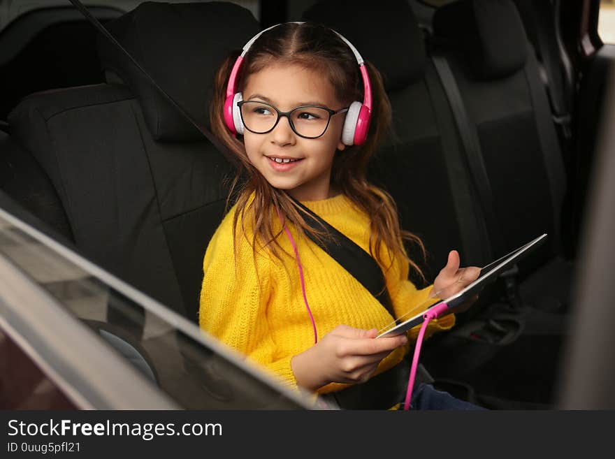 Cute girl listening to audiobook in car