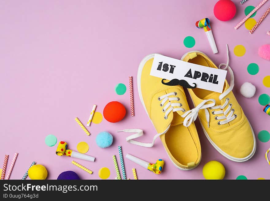 Shoes tied together and note with phrase 1st APRIL on background, flat lay. Space for text