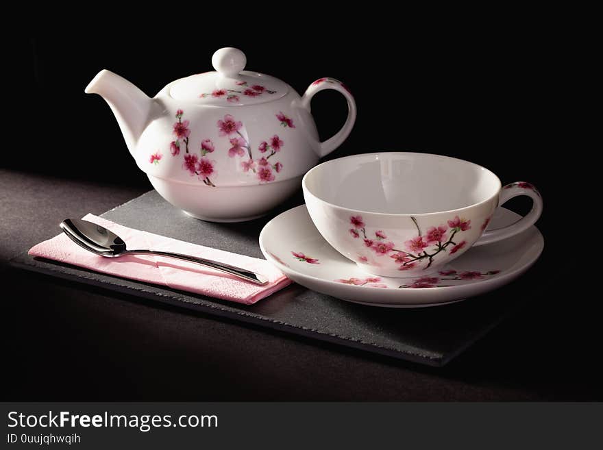 Cup of Tea and Teapot on the slate plate in the dark room. Cup of Tea and Teapot on the slate plate in the dark room