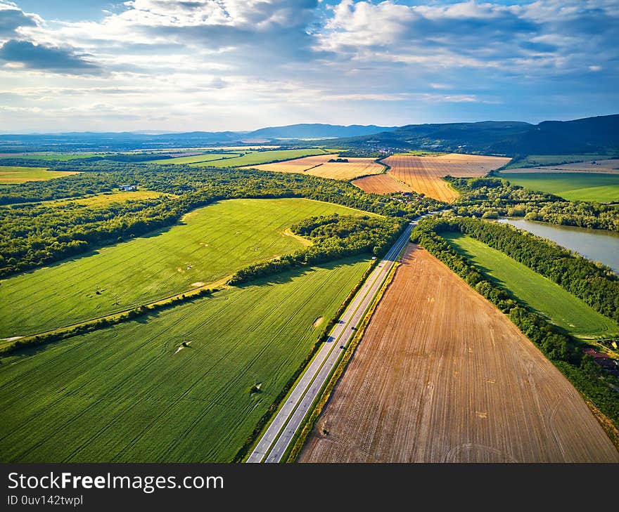 Summer landscape with fields, meadows, lake and mountains. Aerial view