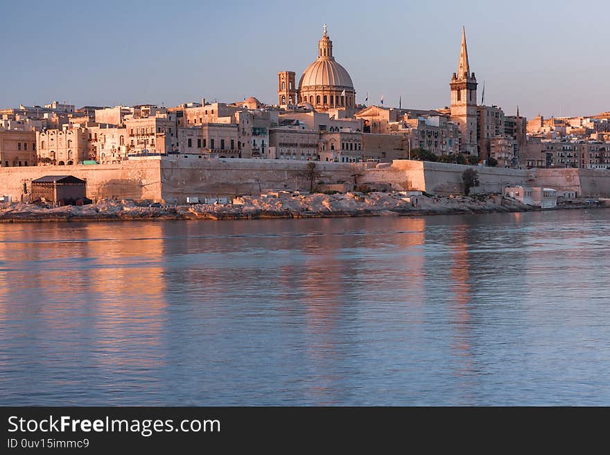 Valletta with Our Lady of Mount Carmel church and St. Paul`s Anglican Pro-Cathedral at sunrise as seen from Sliema, Valletta, Malta. Valletta with Our Lady of Mount Carmel church and St. Paul`s Anglican Pro-Cathedral at sunrise as seen from Sliema, Valletta, Malta