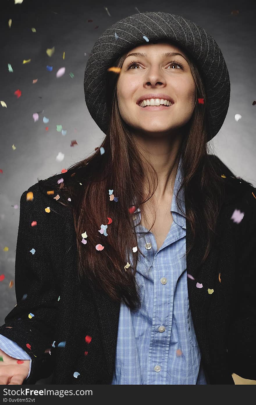 Businesswoman dressed in men`s clothes with confetti at the office