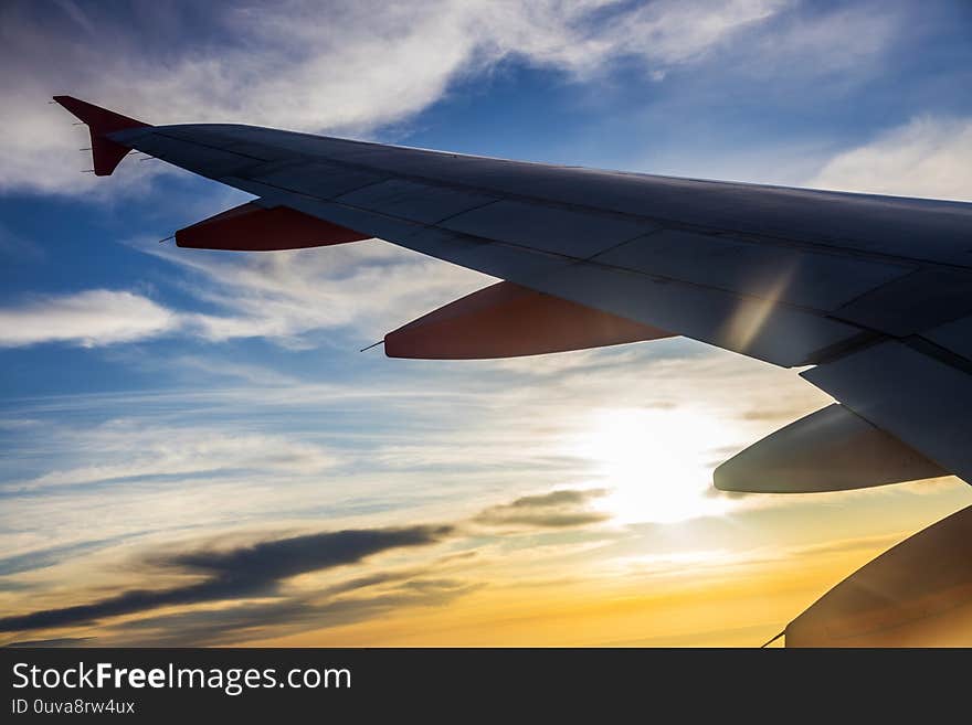 Silhouette of the airplaine - dramatic sunset sky - travelling by air on holiday