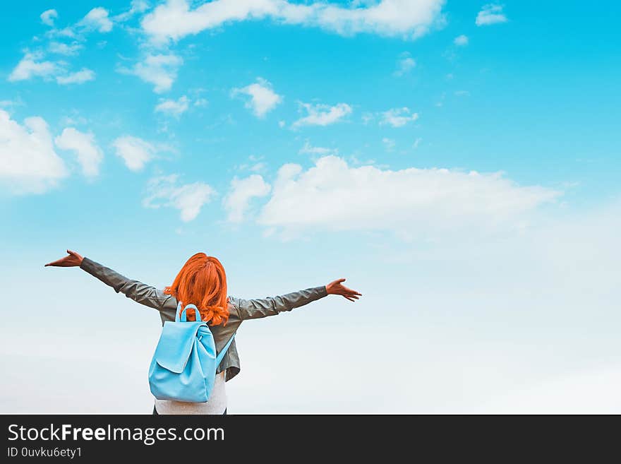 Young redhead woman with backpack enjoying summer day against sky. Freedom of zen. Young redhead woman with backpack enjoying summer day against sky. Freedom of zen