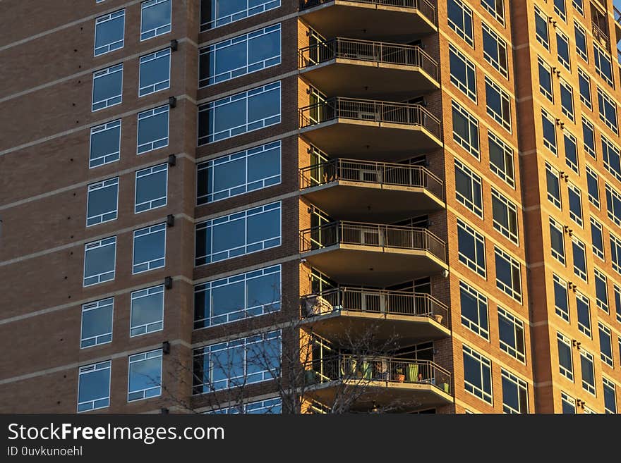 Side lit red brick high rise building with close up of the balconies. Side lit red brick high rise building with close up of the balconies