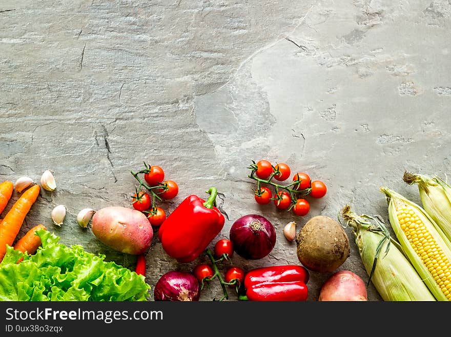 Set of autumn vegetables - potato, cucumber, carrot, greenery - on grey background top-down copy space frame