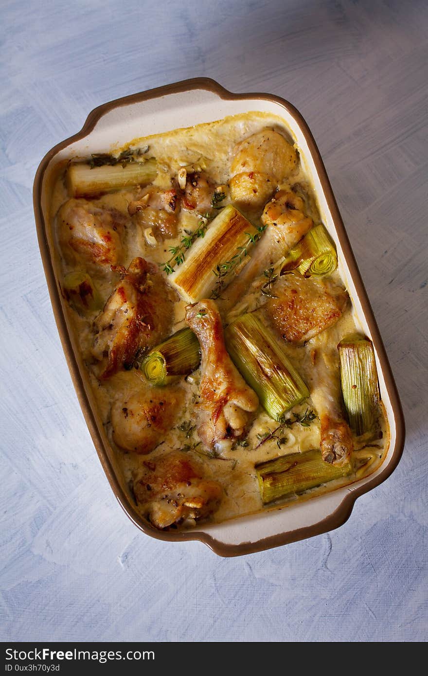 Chicken thighs and legs in sour cream sauce with leek and thyme. Overhead vertical image