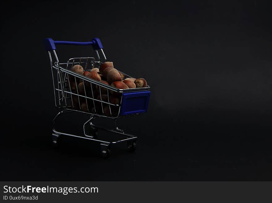 A shopping cart of filbert isolated on black background close up. Image contains copy space