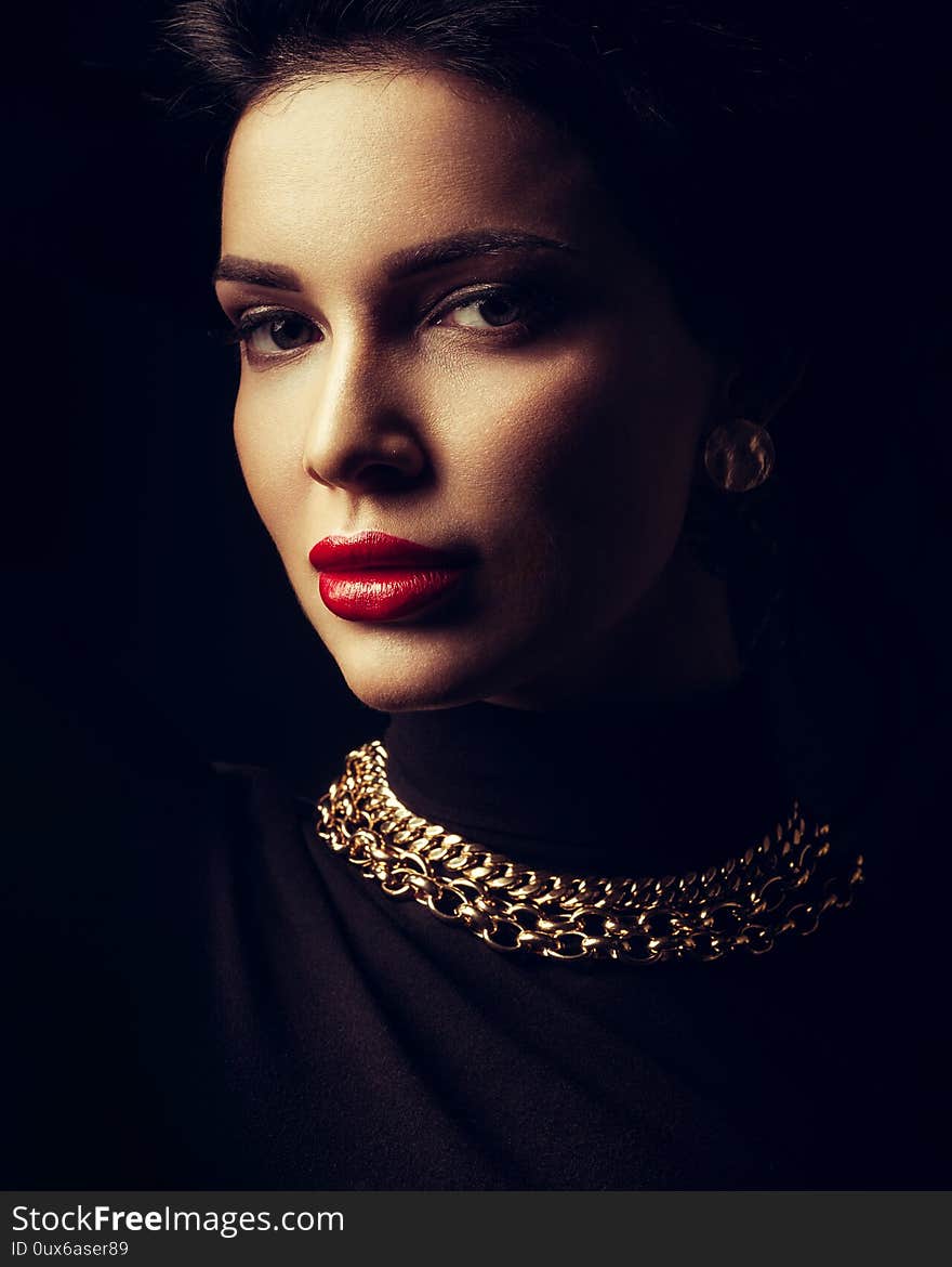 Jewelry and beauty concept - beautiful brunette lady portrait in modern gems and black roll-neck sweater on black background. Jewelry and beauty concept - beautiful brunette lady portrait in modern gems and black roll-neck sweater on black background