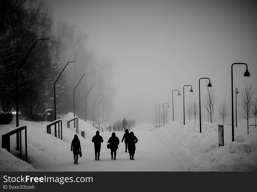 People in winter fog with lamp post in black and white