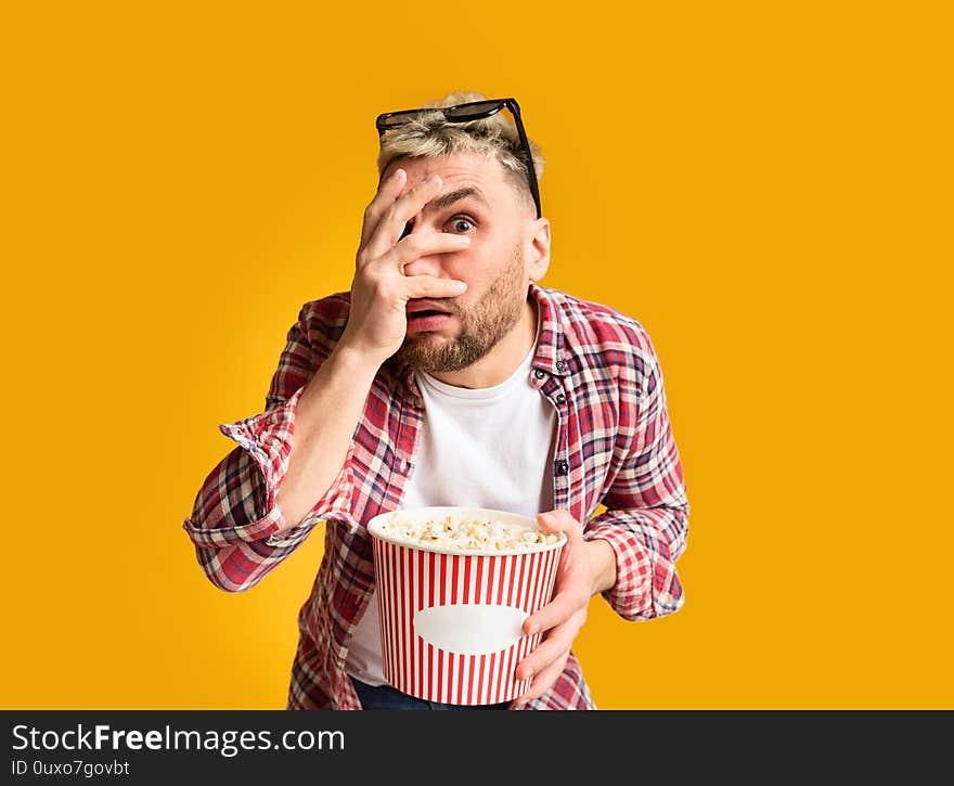 Shocked guy closes eyes his hand, holding bucket