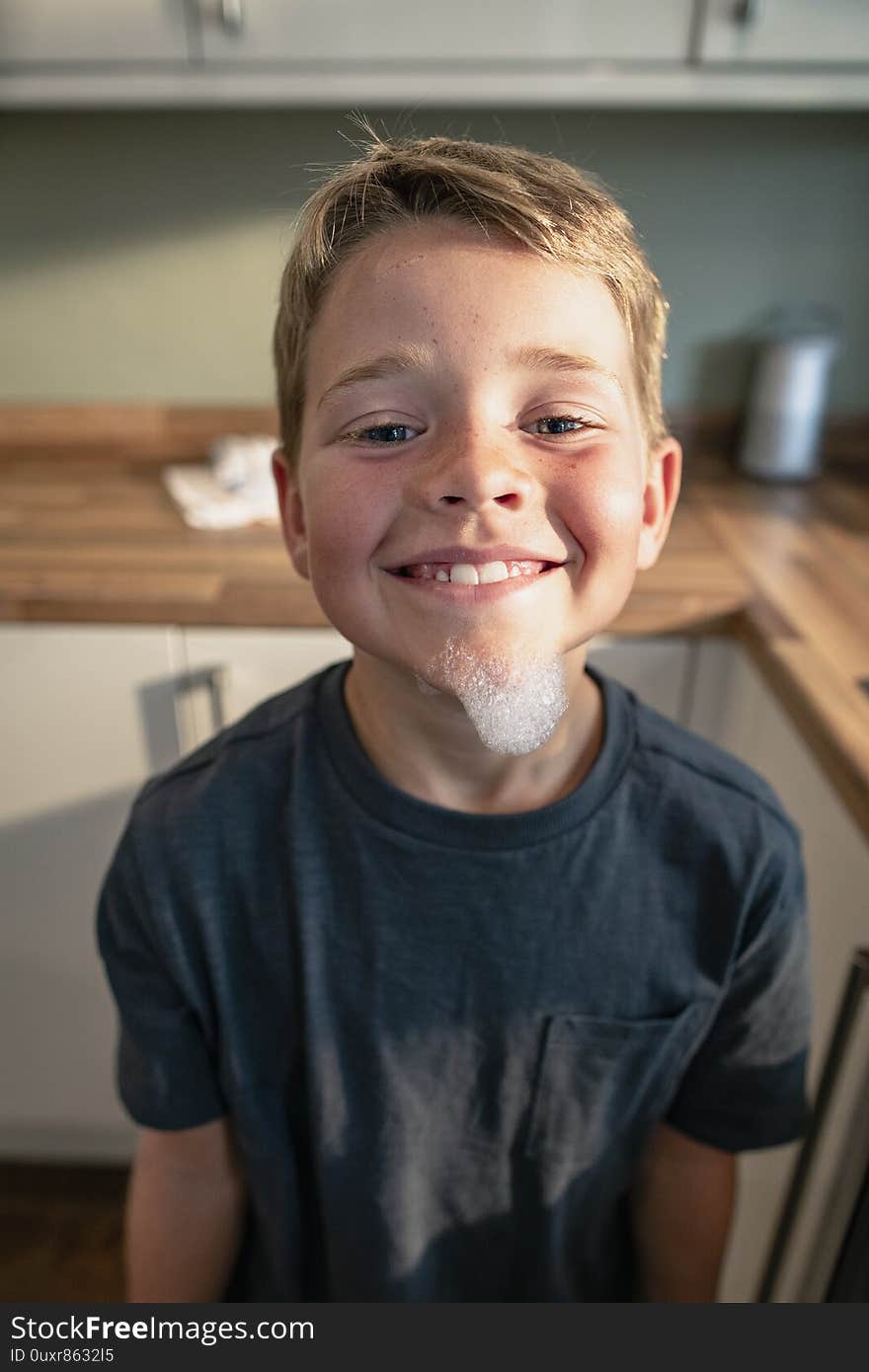 A front view shot of a young boy smiling and looking at the camera, he has bubbles on his face. A front view shot of a young boy smiling and looking at the camera, he has bubbles on his face