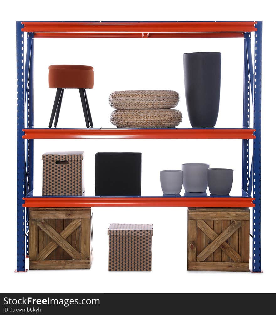 Bright metal shelving unit with wooden crates and different household stuff on white background