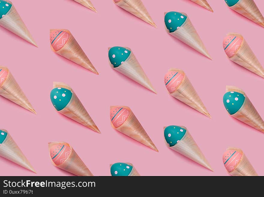 Pattern with colored decorated eggs in bamboo cones looks like ice cream on pink background. Concept of Easter, zero waste, ecology