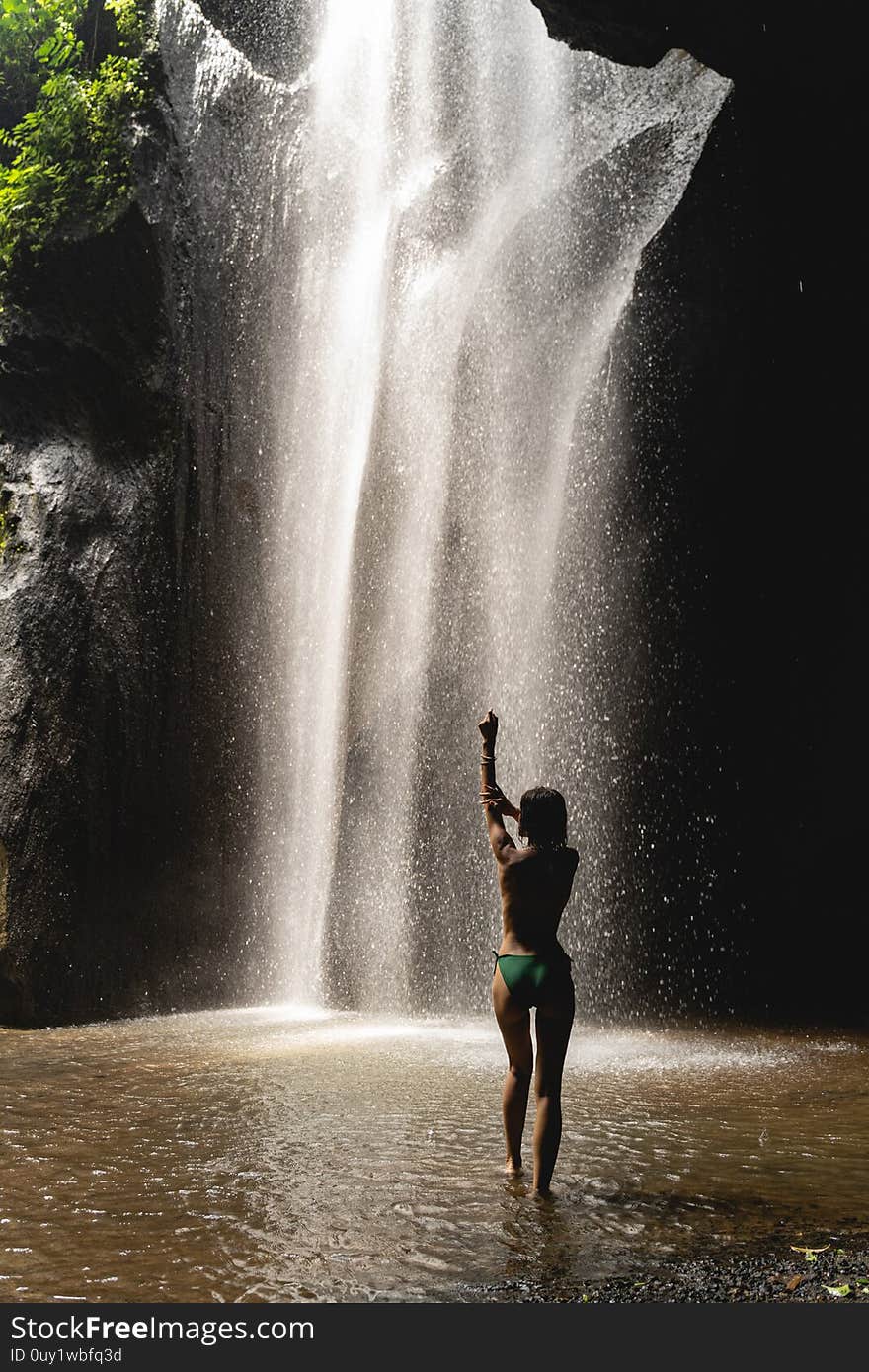 Attractive female person enjoying her washing in cave